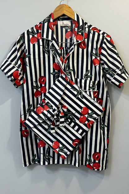 Blue and white striped fabric with red cherries on a wooden surface